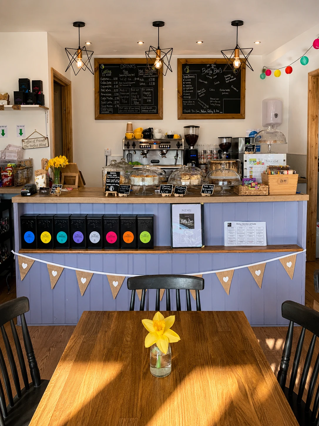 The coffee counter and a sunlit table inside Betty Bee's Coffee Shop
