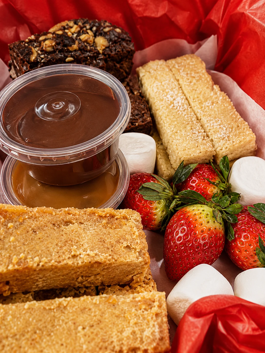 A takeaway treat box with cakes, strawberries and marshmallows from Betty Bee's