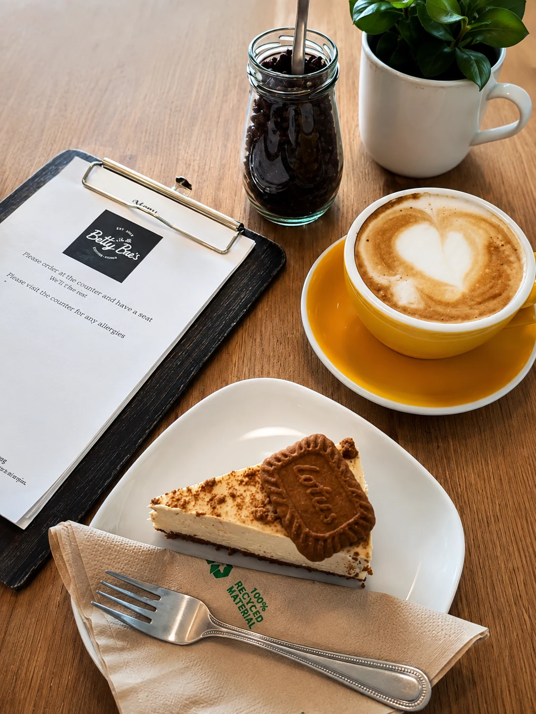 A latte and slice of cake on a table at Betty Bee's